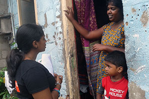 Chamathya (left) polls local families and women about their living conditions. Photo: Setavya Mudalige