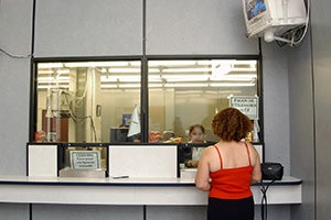 Woman getting her remittance: Many women left behind rely on remittances for their survival. @IOM 2012