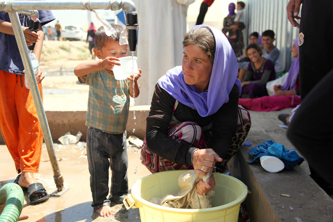 Yazidi woman washing clothes