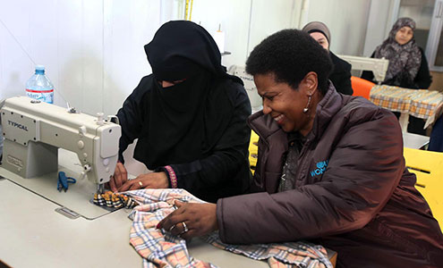 UN Women Executive Director Phumzile Mlambo-Ngcuka takes part in tailoring activities during a visit to the Za'atari refugee camp for Syrian refugees during her trip to Jordan from 20 to 23 February 2014. Photo: UN Women Jordan/Abdullah Ayoub