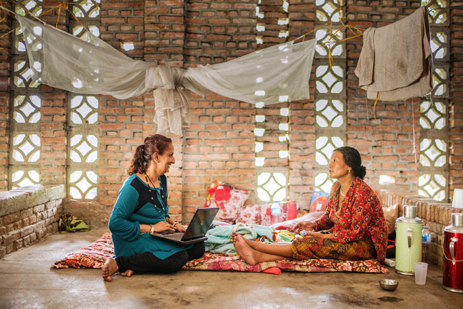Sujata sharma Poudel, supervisor  of the Center for Victims of Torture and a psychosocial counsellor sits with a survivor  in Panchkhal on July 1,2015