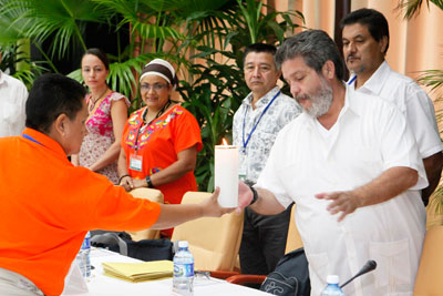 En un acto simbólico de la Cuarta Delegación de Víctimas ante la Mesa de Conversaciones de la Habana en  noviembre de 2014, Nora Elisa Vélez, representante de las víctimas LGTBI y mujer desplazada, entrega una vela a Marcos Calarcá, del equipo negociador de las FARC. Foto cortesía del Gobierno de Cuba