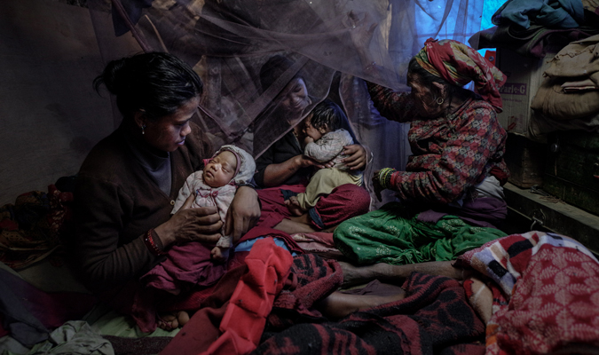 A mother and her newborn baby, together with their family of 12 share this desperate tiny shelter, after their home and all belongings were destroyed by a massive earthquake. Photo: UN Women/Piyavit Thongsa-Ard 