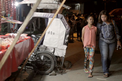A city official is paired with a young girl to survey the night markets in Barangay Bagong Silangan as part of a Women’s Safety Audit on 4 September, 2015. Photo: UN Women/Hubert Tibi