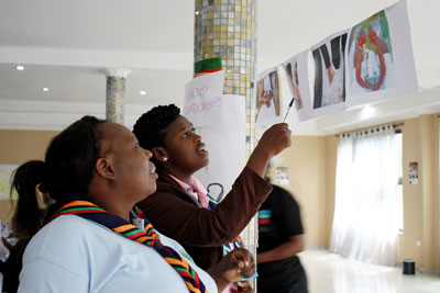 What constitutes a healthy or an unhealthy relationship? Participants examine photographs as part of a train-the-trainers workshop in Zambia. Photo: UN Women/Urjasi Rudra