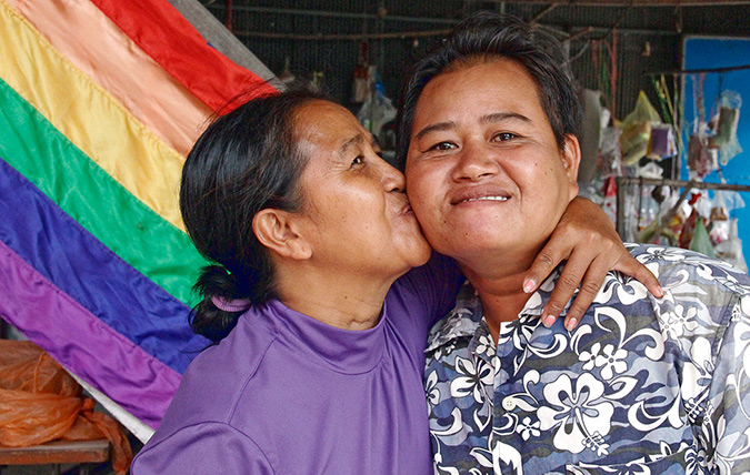 Sao Mimol kisses her partner in front of the LGBT pride flag during the workshop in Takeo. Photo: UN Women/Mariken Harbitz