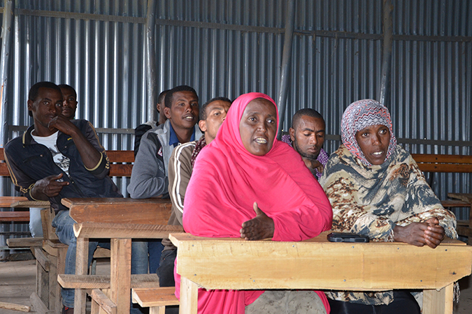 Meliya Gumi (devant à gauche) apporte des idées sur la façon de prévenir la migration irrégulière lors d’un des Débats communautaires de son village. Photo : ONU Femmes/Fikerte Abebe.