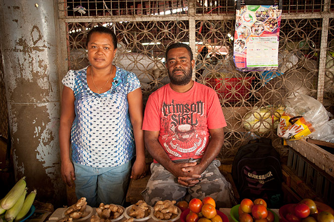 Lusiana Bulu, 38, and her husband Lukekalevu at Ba Market in Fiji's Western Division. The cyclone was already approaching Ba when she left the market to secure her home and by that time it was too late to head to an evacuation centre. They lost their toilet and bathroom and still have no electricity. The market is their only source of income, but many customers cannot afford the higher prices caused by a shortage of local produce after Tropical Cyclone Winston. Credit: UN Women/Murray Lloyd