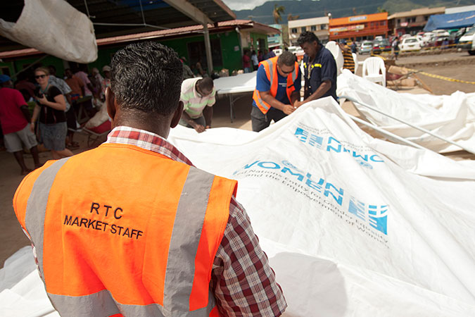 Putting up the tents, tables and chairs provided by UN Women to serve as a temporary market space in Rakiraki. Tropical Cyclone Winston destroyed the market building, depriving hundreds of vendors, most of them women, of a place not only to earn a living, but also to support each other emotionally as they recover. The tents, tables and chairs were provided through UN Women's Markets for Change project, which is funded by the Australian Government. Credit: UN Women/Murray Lloyd