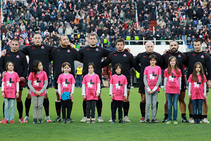 Girls wear HeForShe shirts as they stand with players on the field before the Georgia vs Japan  World Cup Qualifier in November 2014 in Tbilisi, Georgia. Photo: UN Women/Maka Gogaladze