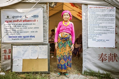 A Woman looking for information stands outside an information centre. UN Women/Samir Jung Thapa