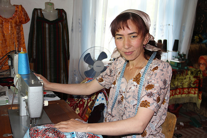 Sayohat Tashbekova accueille les visiteurs dans son atelier où, avec d'autres épouses abandonnées de travailleurs migrants tadjiks, elle crée des objets d'artisanat traditionnel à vendre. Photo: ONU Femmes / Aijamal Duishebaeva.