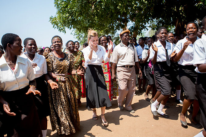 Emma Watson y la jefa principal Inkosi Kachindamoto son recibidas por las niñas de la Escuela Secundaria de Mtakataka en el distrito de Dedza, quienes le cuentan que sus matrimonios infantiles fueron anulados y que pudieron regresar a la escuela. Foto: ONU Mujeres/Karin Schermbrucker.