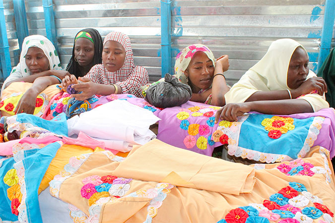 Young women from the Sayam Forage camp sit with products they’ve made after vocational training held at the Women’s Cohesion Space. Photo: REJEA – Niamey