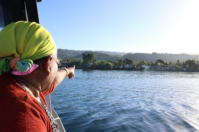 Janet Ramo, President of the Auki Market Vendors Association (MVA) shows UN Women Deputy Executive Director Yannick Glemarec the artificial island where her family lives, constructed from stones and dead corals. Photo credit: UN Women/Caitlin Clifford