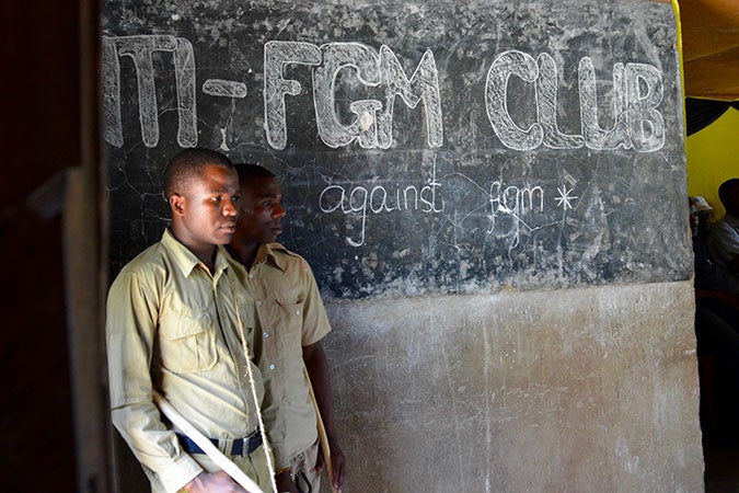 In an educational play performed in front of their school, members of the Anti-FGM club prepare for acting roles as police officers that apprehend FGM practitioners. Photo: UN Women/Deepika Nath