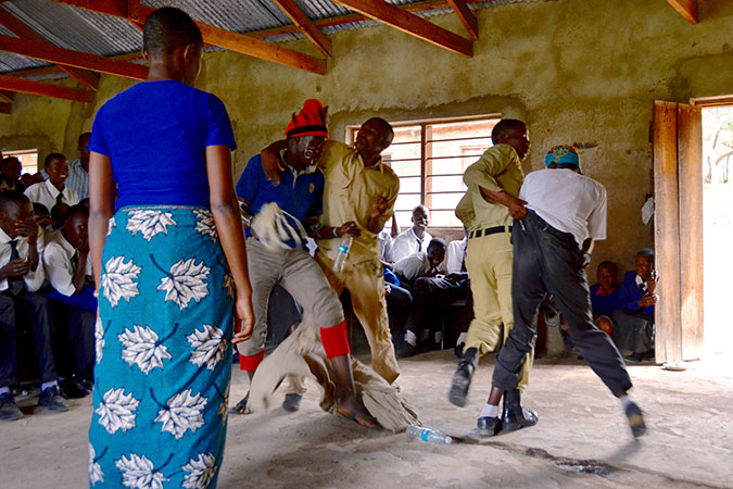 Student actors play police apprehending FGM practitioners - this scene is the highlight of their play, and is always received with loud cheers of approval and laughter. FGM has been criminalized in Tanzania since 1998. Photo: UN Women/Deepika Nath