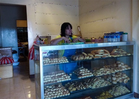 Ellen Elecanal tends her bakery in September 2017. Photo: UN Women/Nuntana Tangwinit