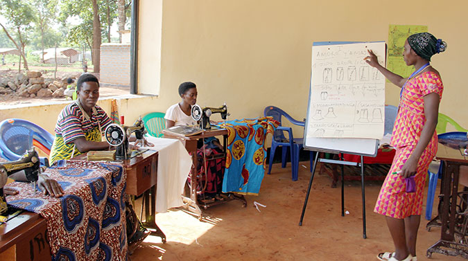 Korotirida Minani and other women refugees practice tailoring in the Nduta Refugee camp. Photo: UN Women/Deepika Nath