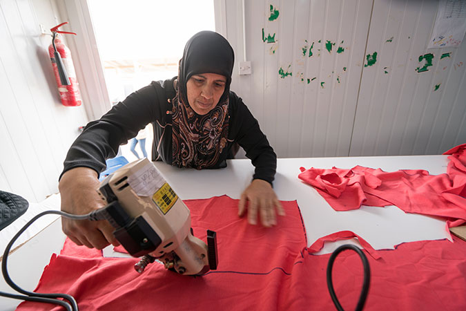 Women work as tailors producing baby clothes in the cash-for-work programme in the UN Women-run Oasis in the Za’atari refugee camp. Photo: UN Women/Christopher Herwig