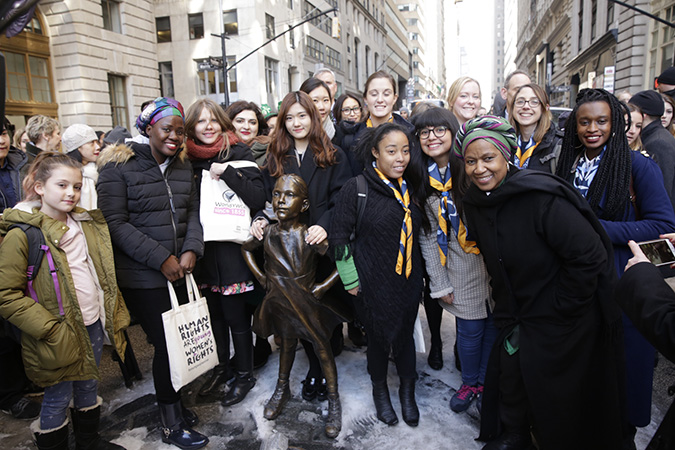 UN Women Executive Director Phumzile Mlambo-Ngcuka meets with young women and girl activists at the Fearless Girl statue on Wall Street. Photo: UN Women/Ryan Brown 