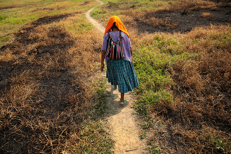 Maria Ba Cal walks down a dirt path. Photo: UN Women/Ryan Brown