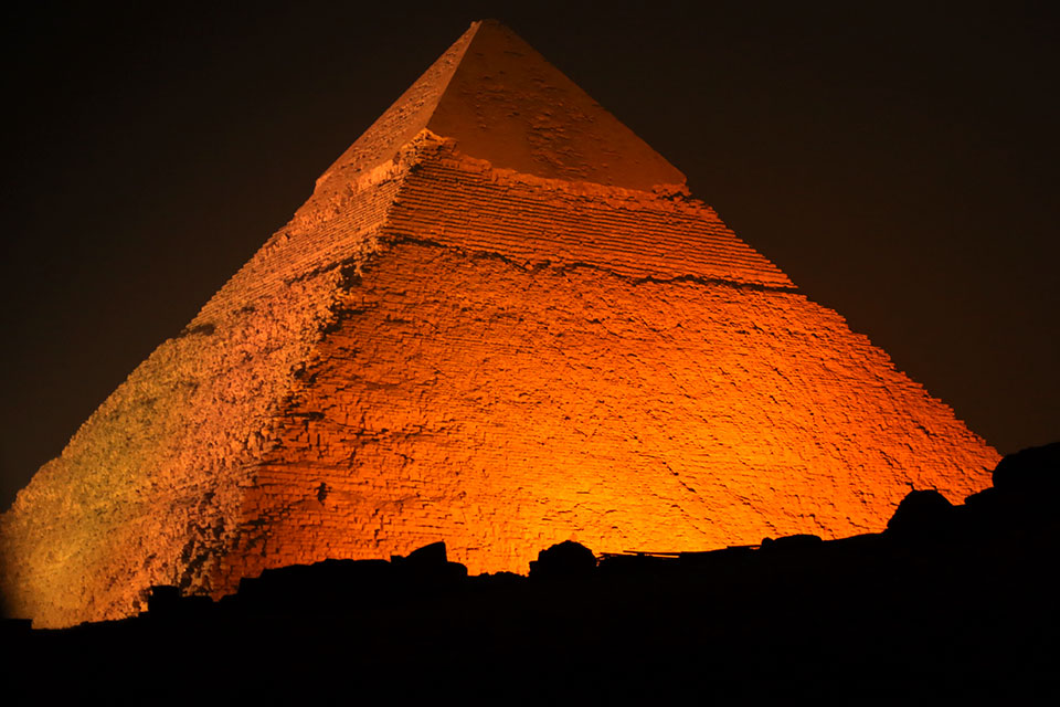 The majestic Giza pyramids lit up in orange. Photo: UN Women/Alex Maher