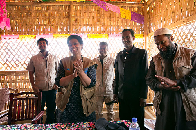 UN Women Executive Director, Phumzile Mlambo-Ngcuka claps after she pins "HeForShe" pins on CIC's in charge of camps, Shamimul Huq Pavel, Muhammed Talut, and ASM Obaidullah in Balukhali Rohingya Refugee camp. UN Women/Allison Joyce