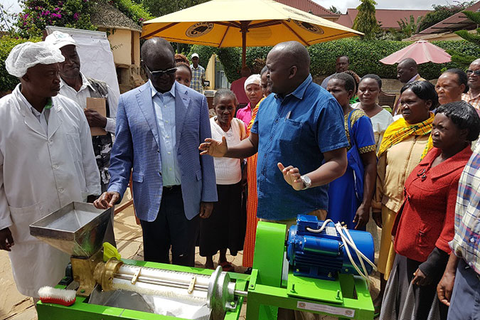 Kiraitu Murungi, Governor Meru County inspects the fruit processing technology and is briefed by Jomo Kenyatta University of Agriculture and Technology (JKUAT) engineers led by professor David Sila. Photo: UN Women/Faith Bwibo