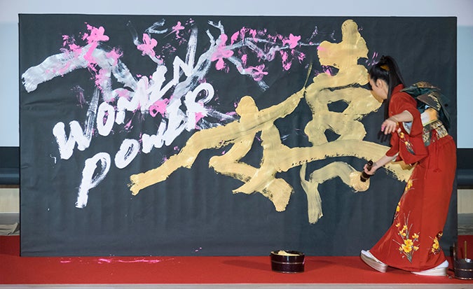 Yuuna Okanishi dramatically stylized calligraphy on stage to live piano music provided by Takashi Matsunaga. Photo: UN Women/STORY CO., LTD