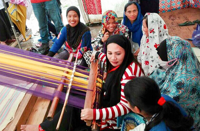 Women displaced by the Marawi battle being trained in traditional weaving techniques to produce textiles. Photo: UN Women/Maricel Aguilar