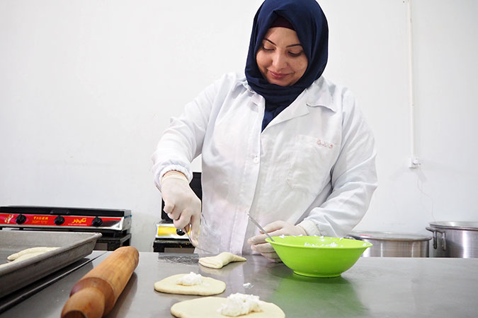 Warda Hassan, a survivor of violence and a trainee at Food Incubator, making cheese stuffed pastries. Photo: UN Women/Eunjin Jeong