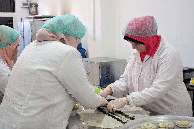 Lubna Masalha (right), a survivor of violence and a trainee at Food Incubator, making traditional Palestinian pastries. Photo: UN Women/Eunjin Jeong