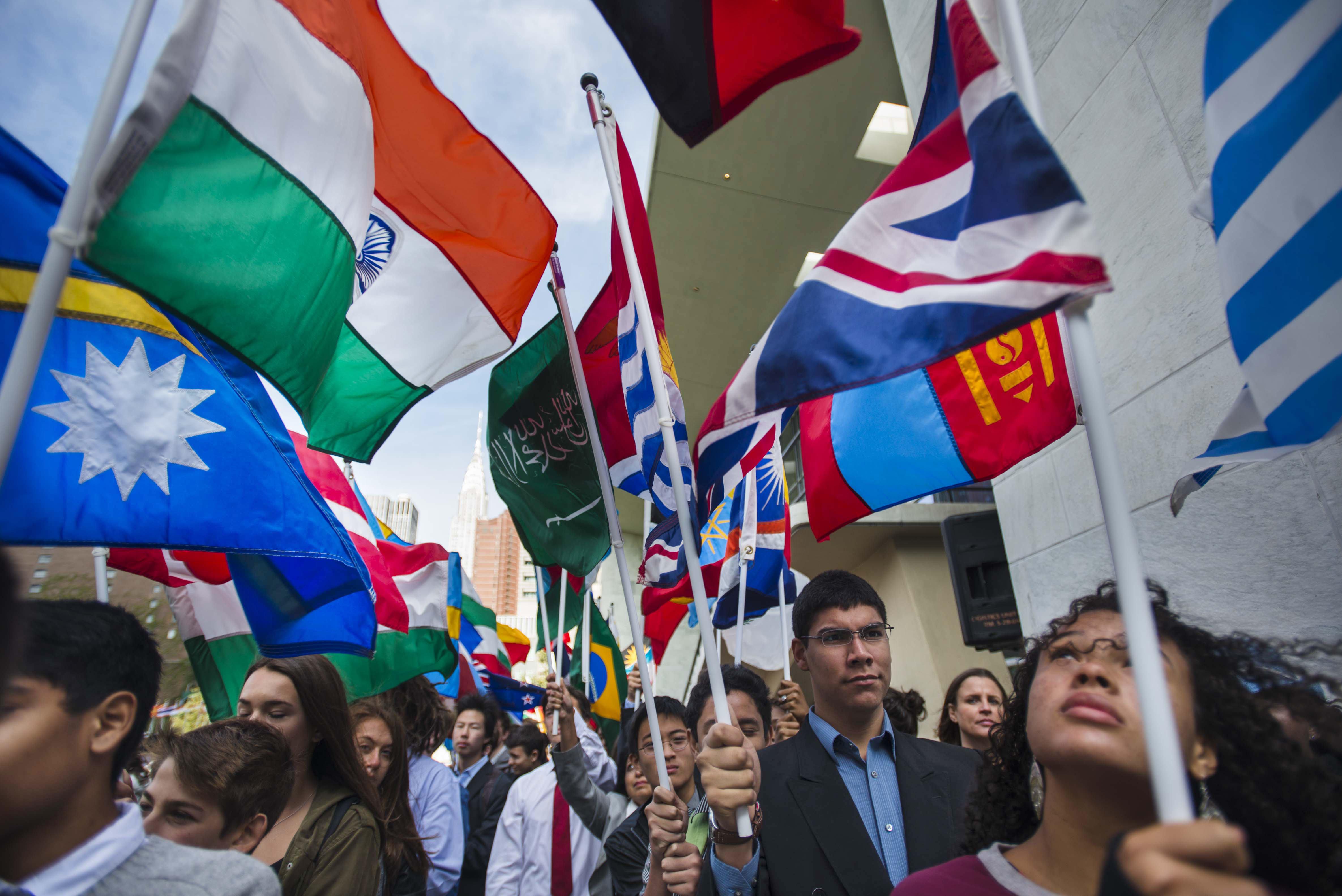 Students  carry  the  flags  of  United  Nations  Member  States  during  the  annual  Peace  Bell  Ceremony  held  in  observance  of  the  International  Day  of  Peace  (21  September),  ahead  of  the  70th  session  of  the  General  Assembly Photo: UN Photo/Amanda Voisard