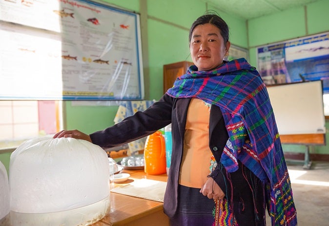 In Hka Shi village, Waingmaw township, a woman enrolled in the catfish farming training says she is thankful she can do it from home, while caring for her baby. Photo: UN Women/Stuart Mannion