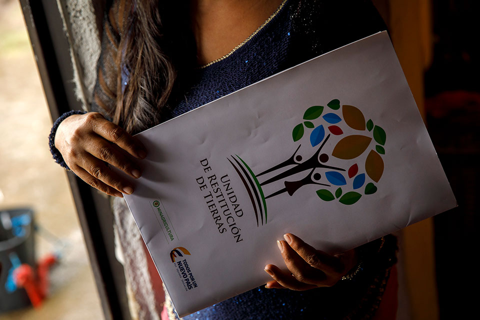 Cielo Gomez holds a folder with land restitution paperwork received during the process initiated by the Government of Colombia. Photo: UN Women/Ryan Brown