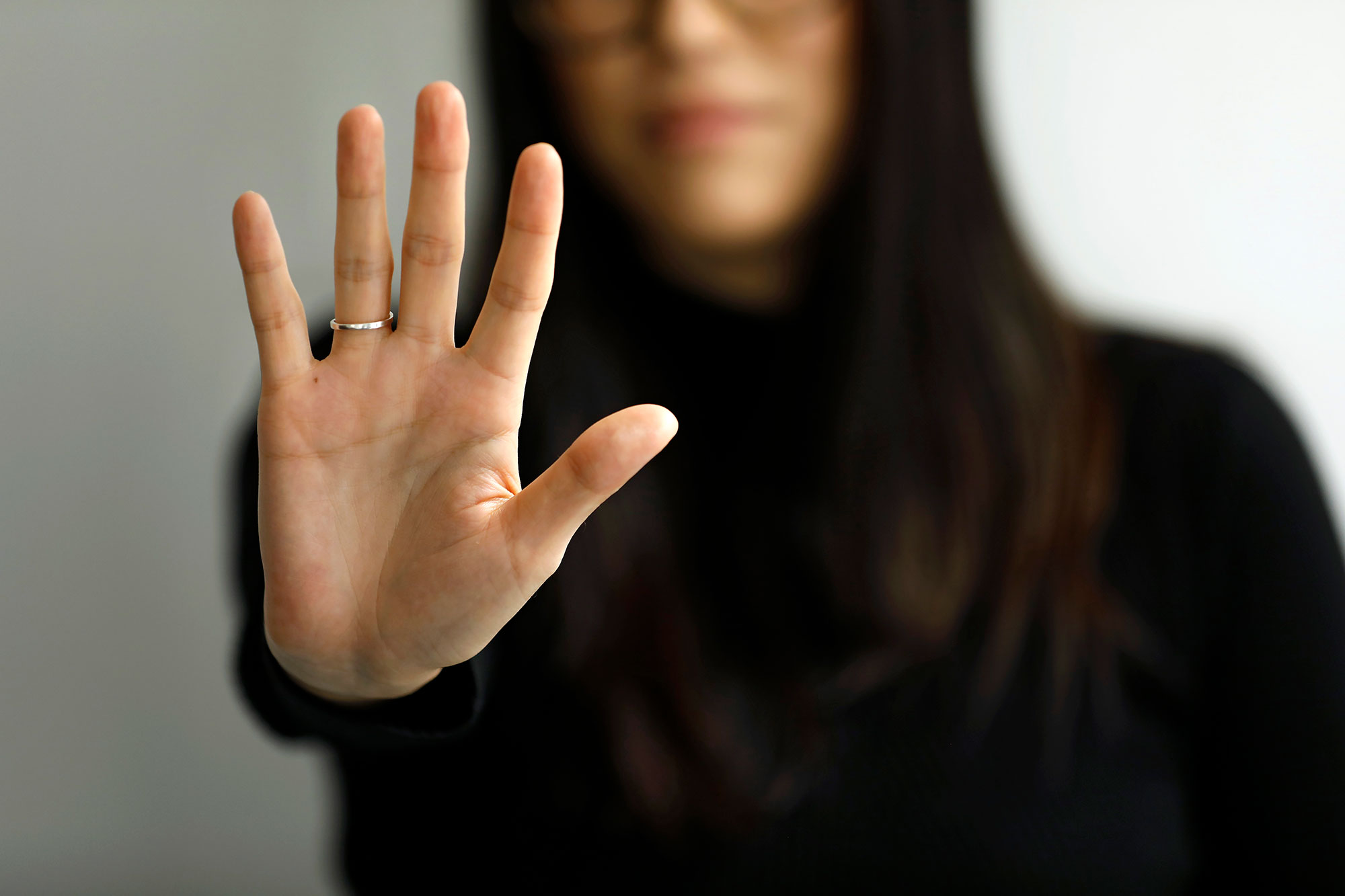 An unidentifiable woman holds up her hand in a "stop" gesture. Photo: UN Women/Ryan Brown
