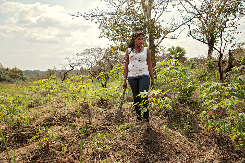 Dorothee Mbogo with her cassava crop which she farms in addition to her retail business. Photo: UN Women/Ryan Brown