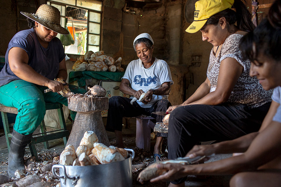 Janete Dantas, second right, with her mother, Maria Nilda, centre, and her sisters, Mayla, left, and Leni, right, shucks cassava skins. Photo: Lianne Milton