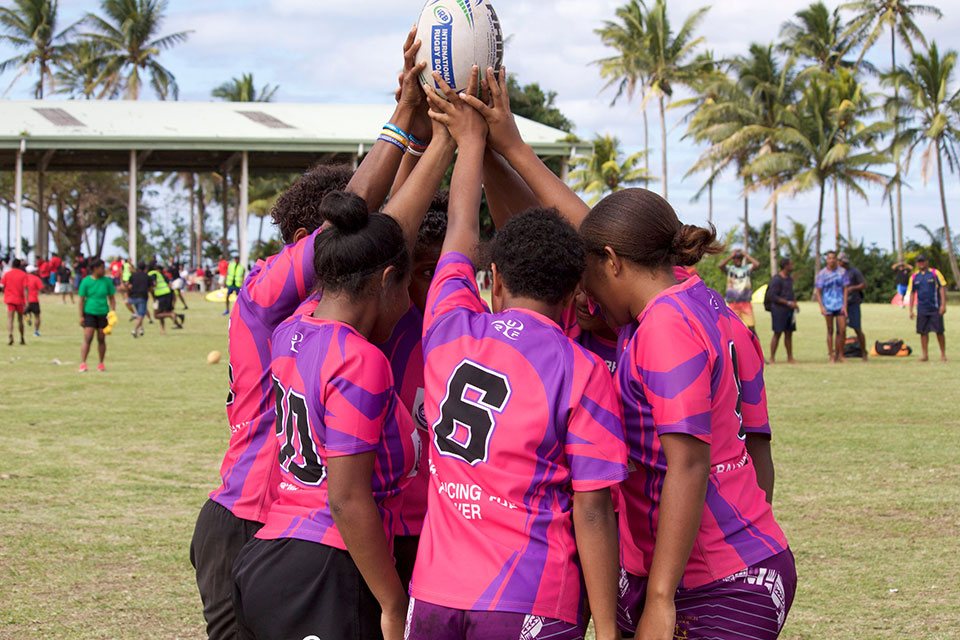 A group of girl rugby players huddle in Fiji. Photo: Oceania Rugby