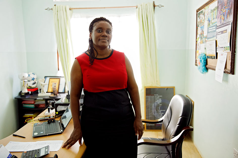 Dorcas Amakobe poses for a photo in her office. Photo: UN Women/Ryan Brown