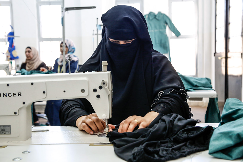Mona Ahmed Alqkla, 39, has found an incentive-based volunteer opportunity as a tailor at the UN Women Oasis Centre in Taibeh. Photo: UN Women/Lauren Rooney