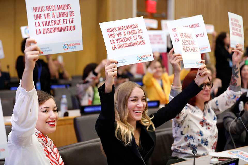 Attendees of the Gender equality: from the Biarritz Partnership to the Generation Equality Forum event hold up some of their gender equality demands. 