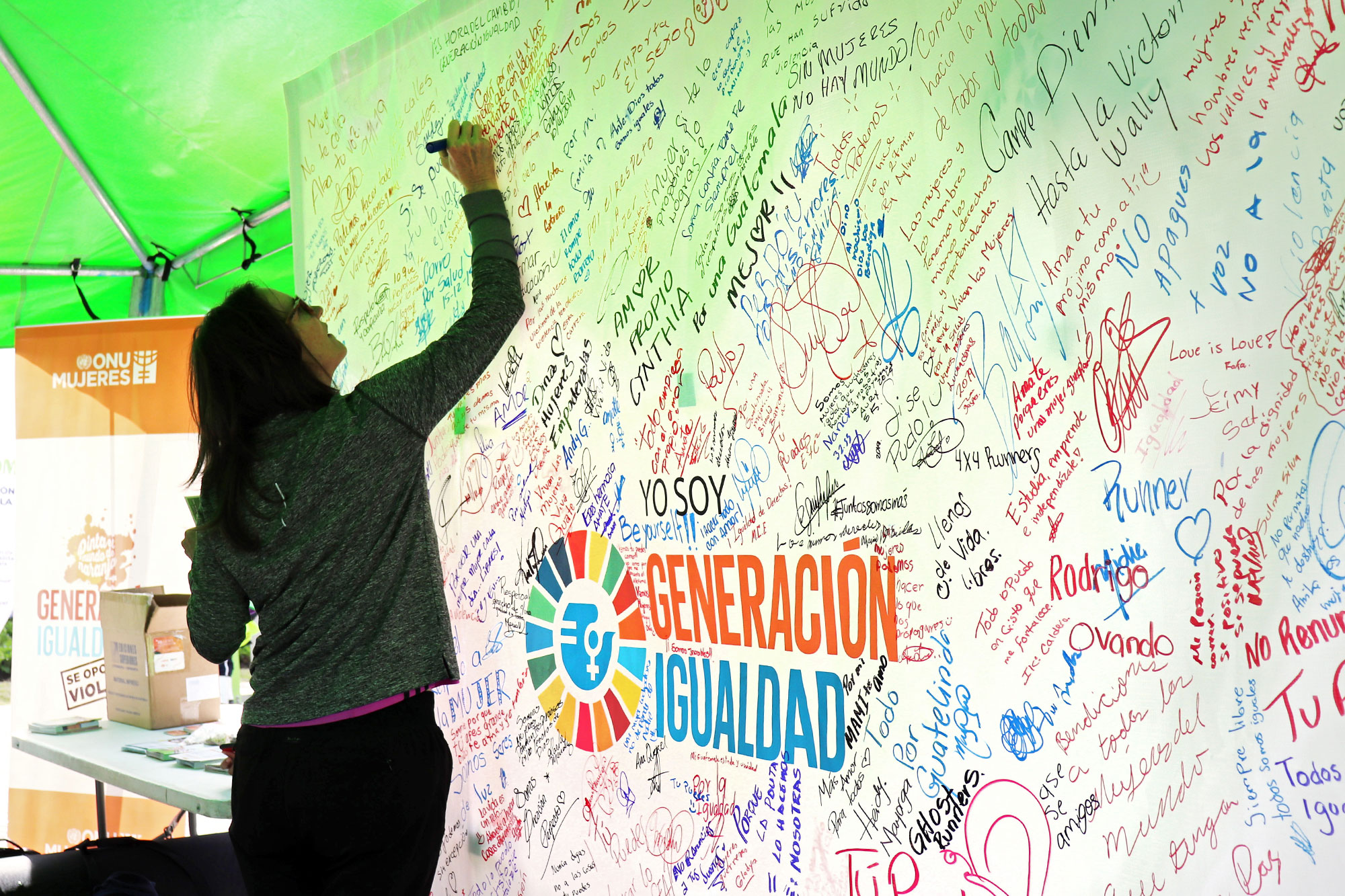 women in Guatemala sign a Generation Equality banner.