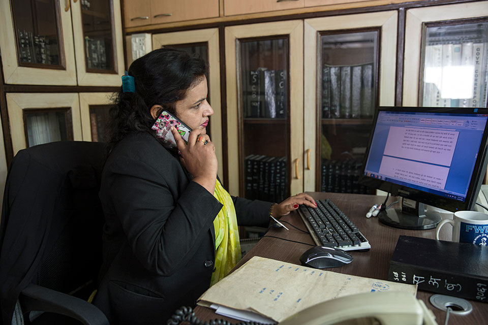 Puspa Poudel, legal officer for the Forum for Women, Law and Development, counsels a client over the phone from her office in Kathmandu, Nepal.Photo: UN Women/Uma Bista