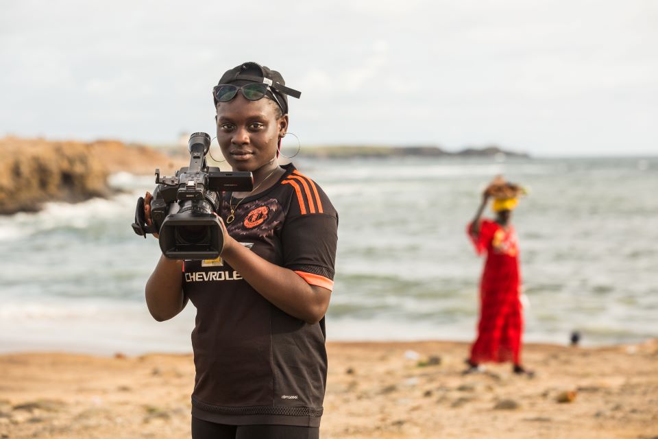 Oumou Kalsoum Diop, 18, poses for a portrait with her video camera on the beach in Dakar. Photo: UNICEF/UNI363224/Tremeau