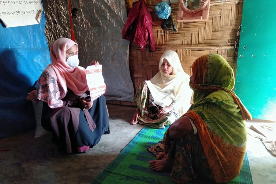 Nurussafa (izquierda) trabaja para informar a la comunidad sobre cómo prevenir la propagación del COVID-19 en el campamento. Fotografía: ONU Mujeres