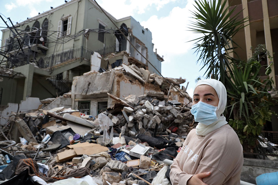 A woman in front of a destroyed house, Karantina, Beirut. August 9, 2020. Photo: Dar Al Mussawir