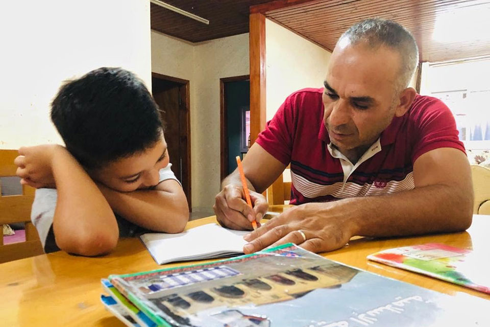 Amer Farragy helps his son Majd with schoolwork. Photos Courtesy Ilham Edaes and Amer El Farrargy