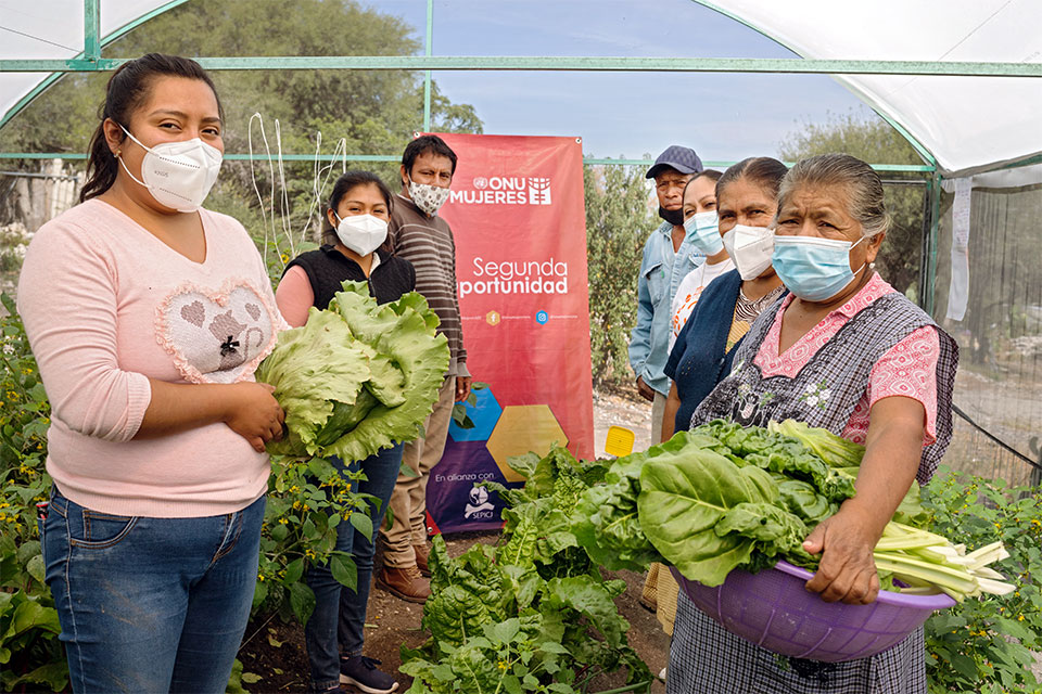 Participants from the Sembrando Esperanza (Sowing Hope) module in San Cristóbal Tepeteopán  pose for a photo with vegetables from their greenhouse.  Some in the program sell the vegetables they harvest, others use the produce to feed their families. Photos: UN Women/ Dzilam Méndez
